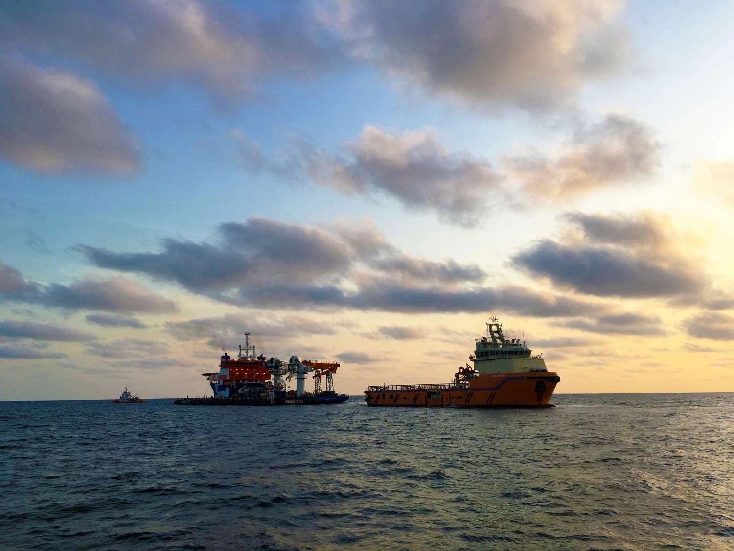 Two offshore vessels at sunset seascape